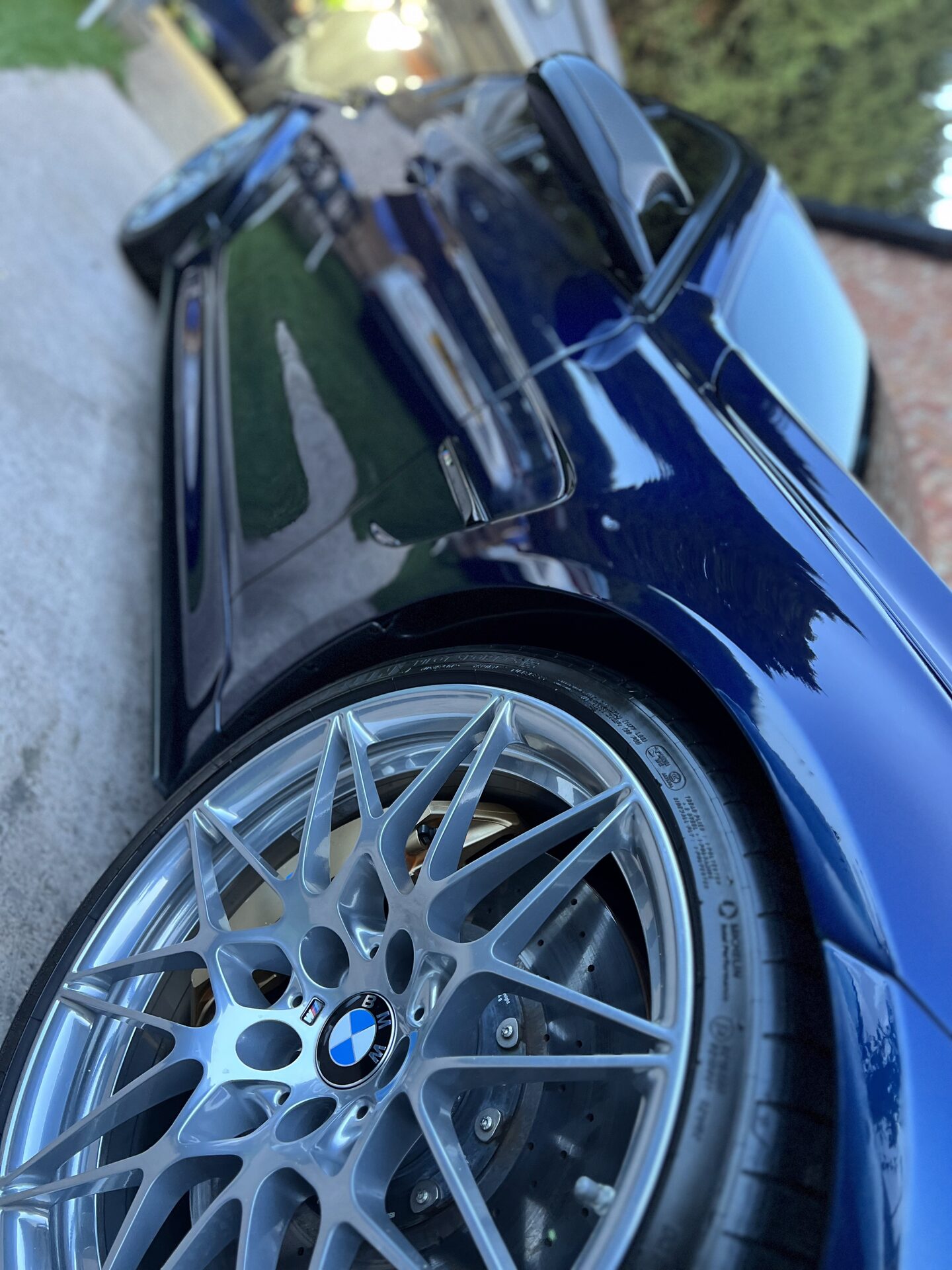 Dual-action machine polisher removing swirl marks from glossy black paintwork