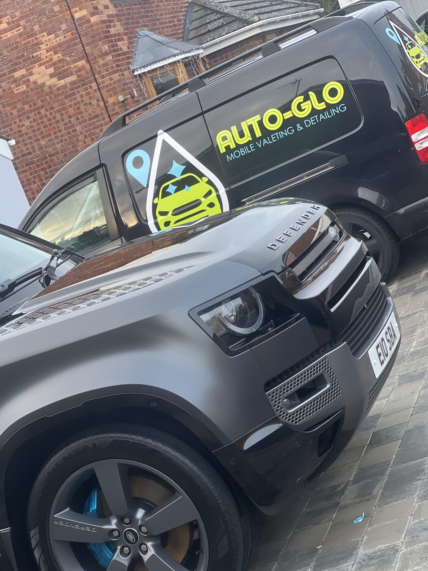 Auto-Glo mobile valeting and detailing van parked alongside a customer's Land Rover Defender on their driveway in Warwickshire — we come to you